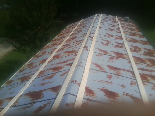 Rusted metal roof panels with new wood purlins before replacement — Storm Damage Roof Repair in Lindale by Roofing Brothers