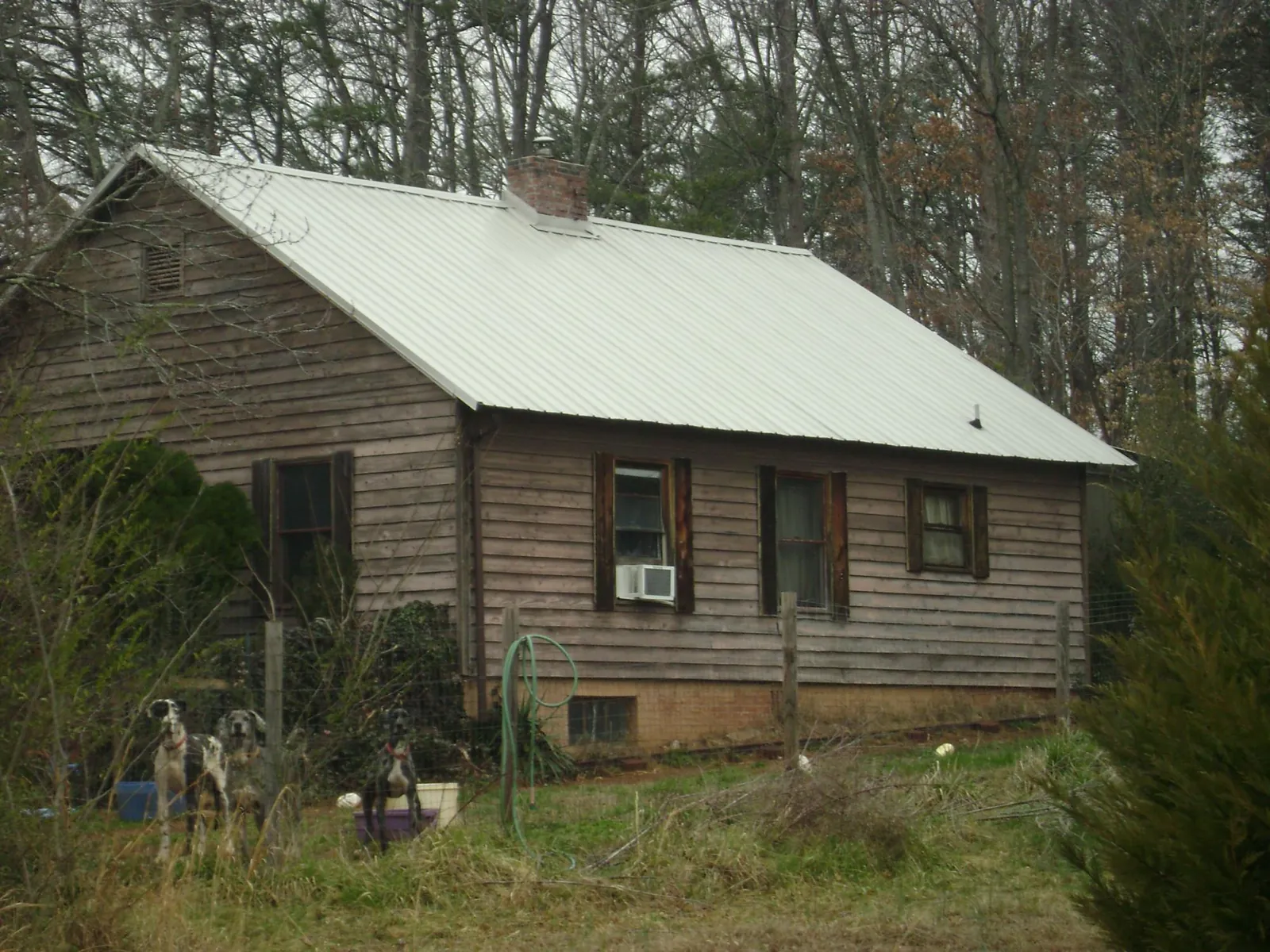 White metal roof on an old wood sided farmhouse, from a Asphalt Shingle Roof Repair job in Lindale